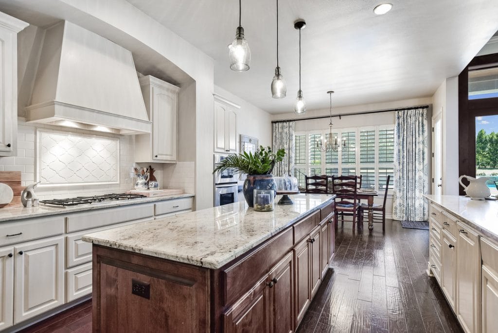 Classic white kitchen with white cabinets, River White granite and subway tile.